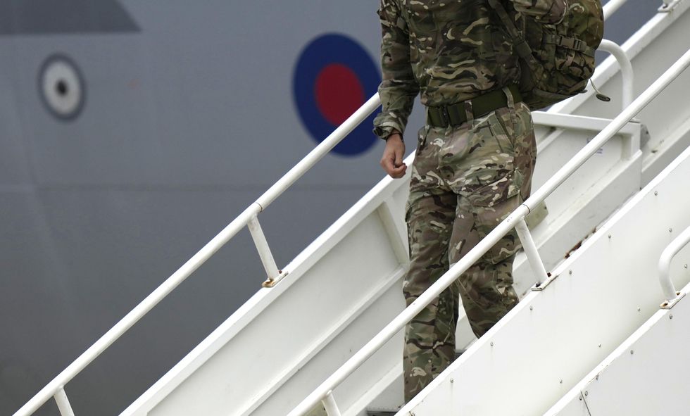 A member of the British Armed Forces' 16 Air Assault Brigade disembarks a RAF Voyager aircraft after returning from Kabul in 2021