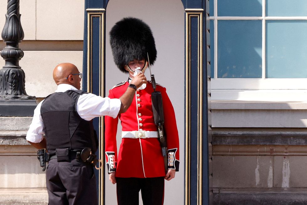 A member of The Queen's Guard receiving a cool drink