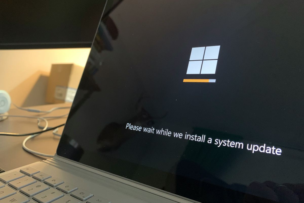 a microsoft laptop is shown installing a system update on-screen 