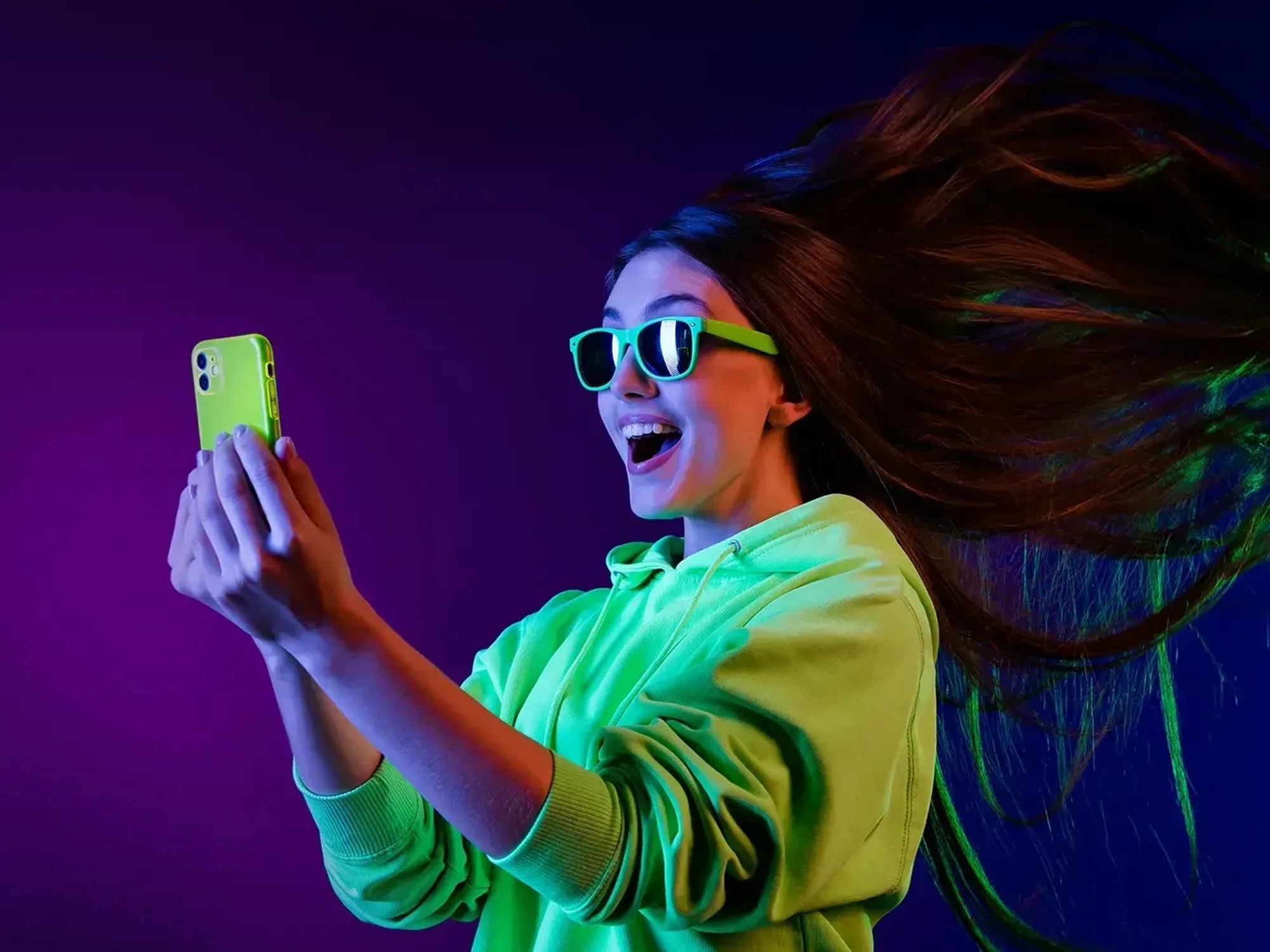 a modal holds a smartphone with the wind blowing in her hair