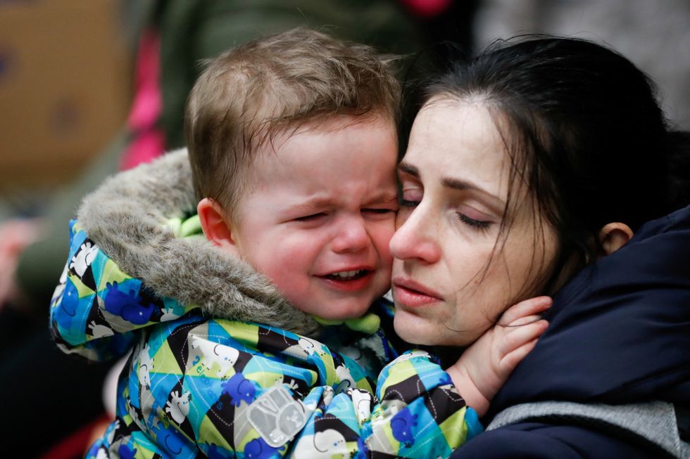 A mother fleeing Russia's invasion of Ukraine comforts her son at a train station in Zahony, Hungary March 5, 2022. REUTERS/Bernadett Szabo