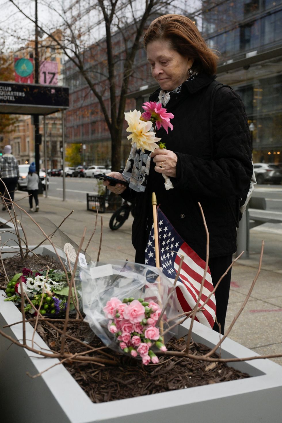 A mourner lays flowers and the American flag flies at a makeshift memorial for Ms Beckstrom