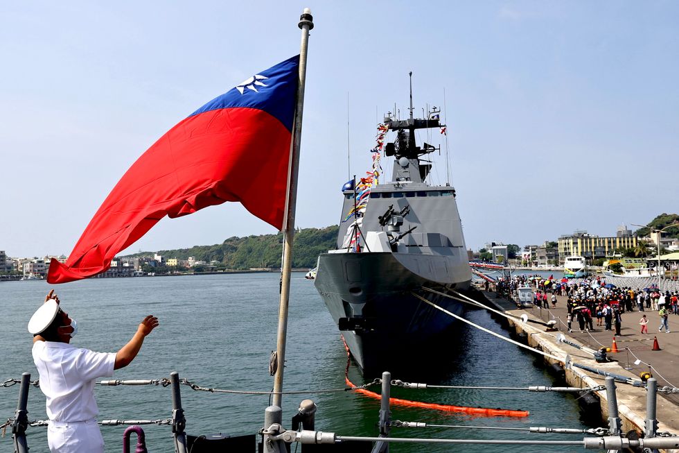 A navy soldier adjusts a Taiwan flag onboard ROCS Chang Chien (PFG2-1109) ahead of the National day celebration in Kaohsiung, Taiwan, October 9, 2021. REUTERS/Ann Wang