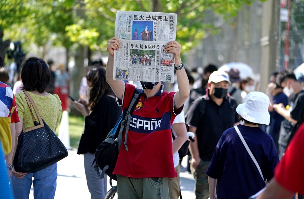 A newspaper is held up in protest outside the Olympic Stadium.