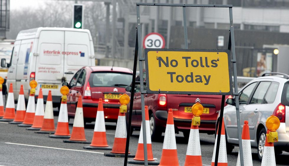 A 'No Tolls Today' sign with car traffic behind