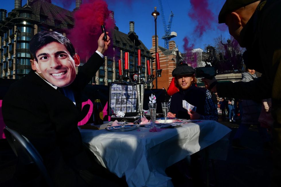 A number of individuals blocked the road on Westminster Bridge, London, with a theatrical dinner scene, to highlight their plea for the Government to sever ties with animal farming and invest in a plant-based future.