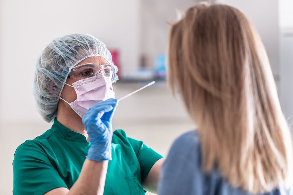 A nurse conducts a Covid test