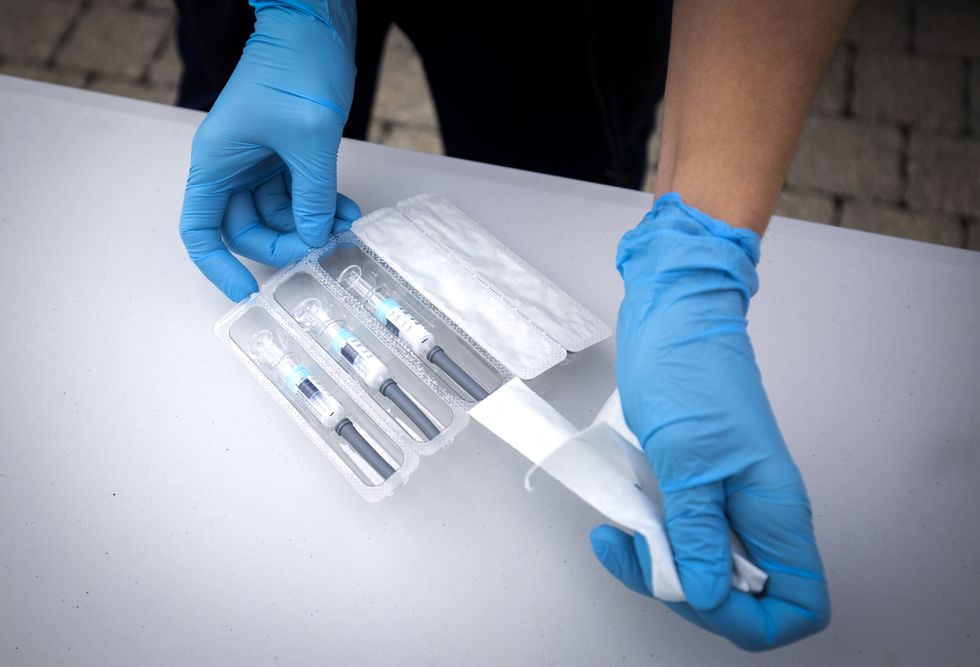 A nurse prepares flu vaccine jabs at one of the new the drive-thru flu clinics at Little France, Edinburgh.