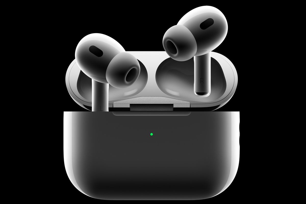 a pair of airpods pro protrude from the charging case against a black background
