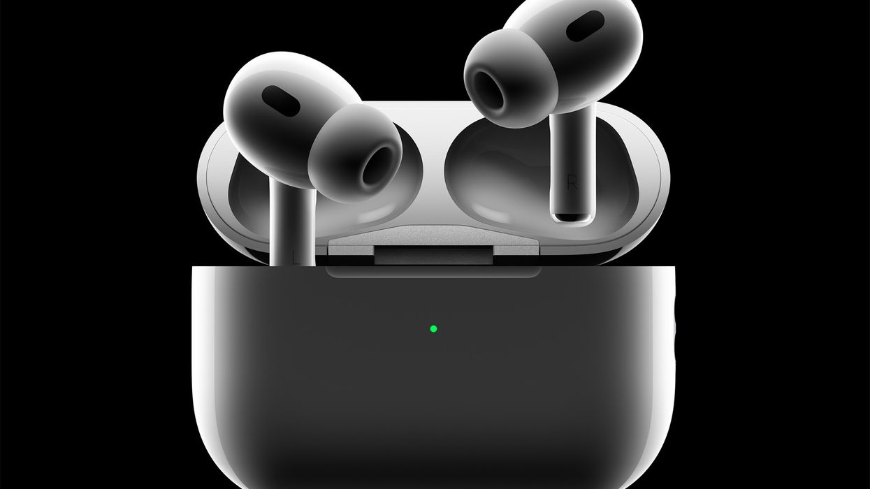 a pair of airpods pro protrude from the charging case against a black background