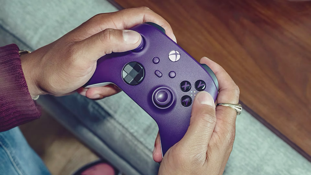 a pair of hands hold the astral purple xbox series wireless controller