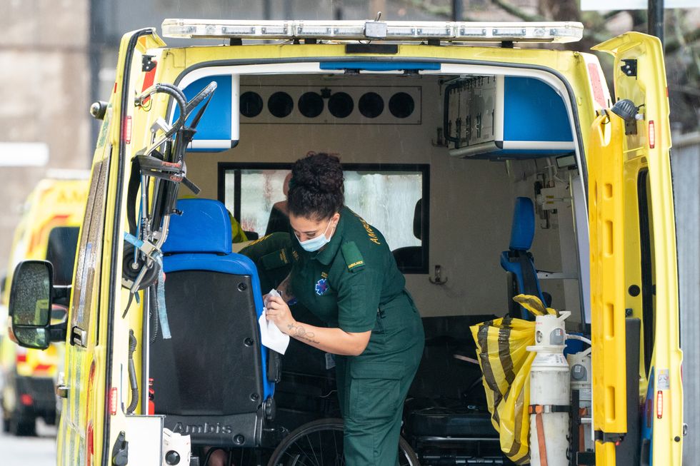 A paramedic cleans the rear bay of an ambulance outside the Royal London Hospital, in London. Picture date: Monday December 27, 2021.