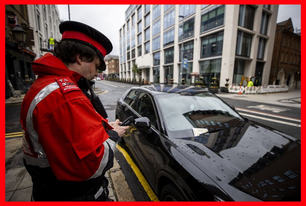 A parking warden handing a fine to a parked vehicle.
