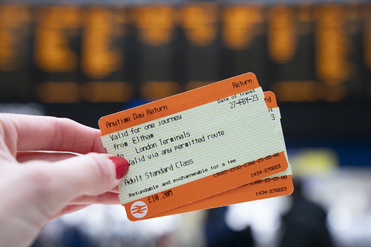 A passenger holds train tickets at a station