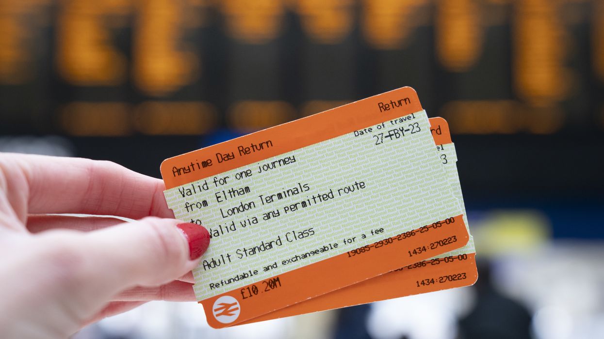A passenger holds train tickets at a station