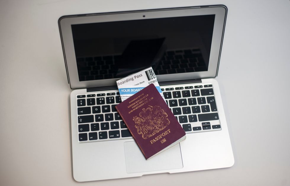 A passport containing airline boarding passes on top of a laptop. The UK and US have banned large electronic devices including laptops and tablets in cabin baggage on certain inbound flights as a security measure.
