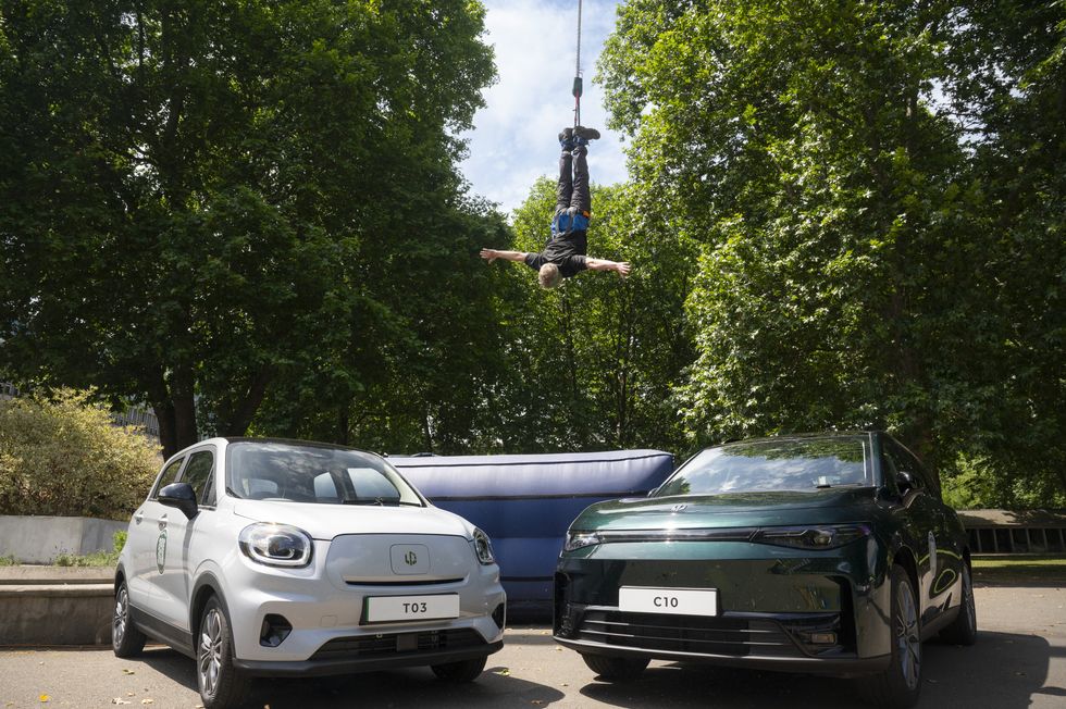 A person bungee jumping in front of the Leapmotor T03 and C10