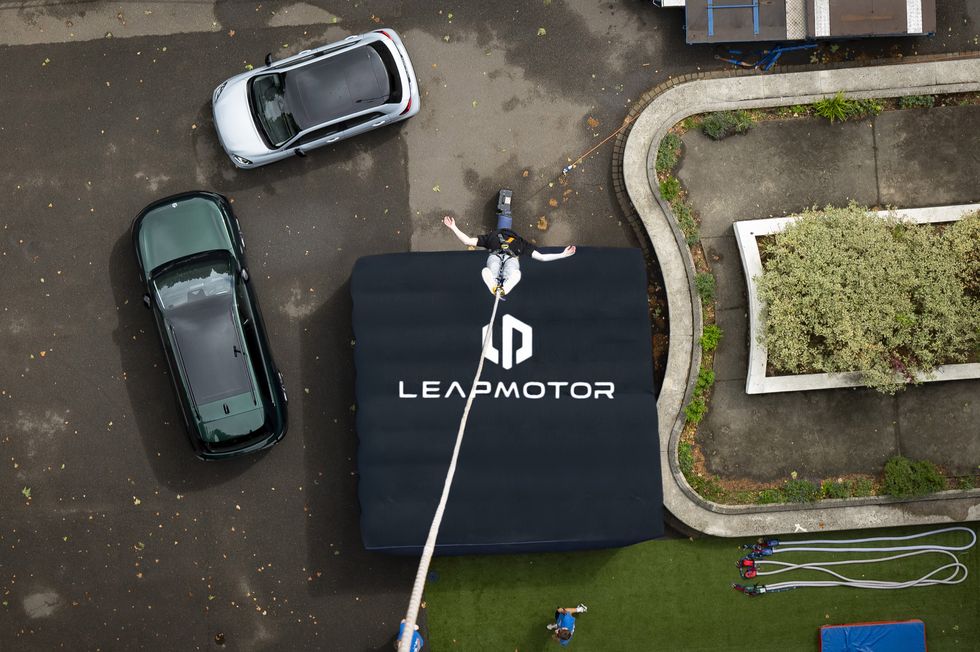 A person bungee jumping in front of the Leapmotor T03 and C10