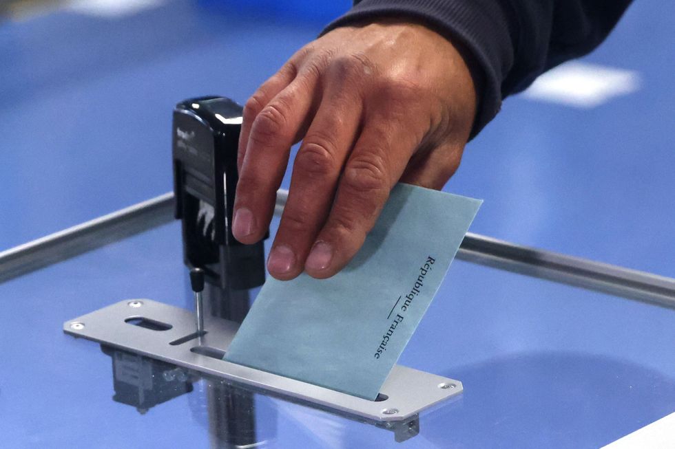 A person casts a ballot in the second round of the 2022 French presidential election at a polling station in Henin-Beaumont, France, April 24, 2022. REUTERS/Yves Herman