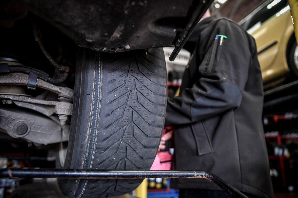 A person checking a tyre