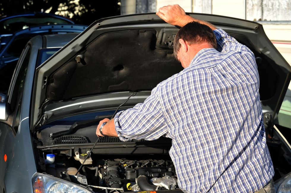 A person checking their car engine