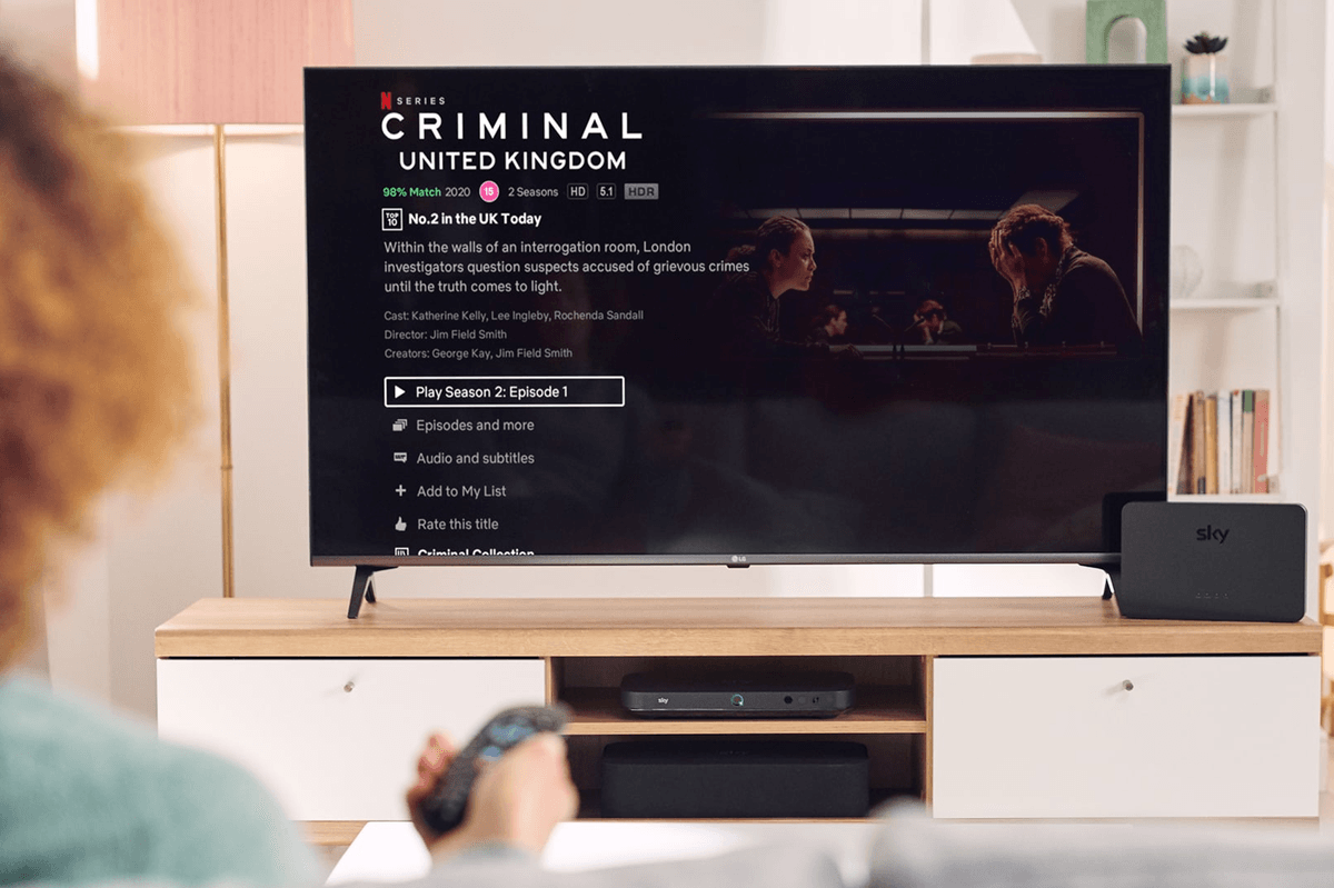 a person holds out their sky tv remote to select an episode of a netflix show on sky tv