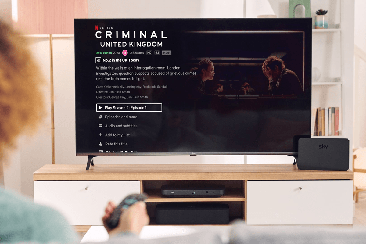 a person holds out their sky tv remote to select an episode of a netflix show on sky tv