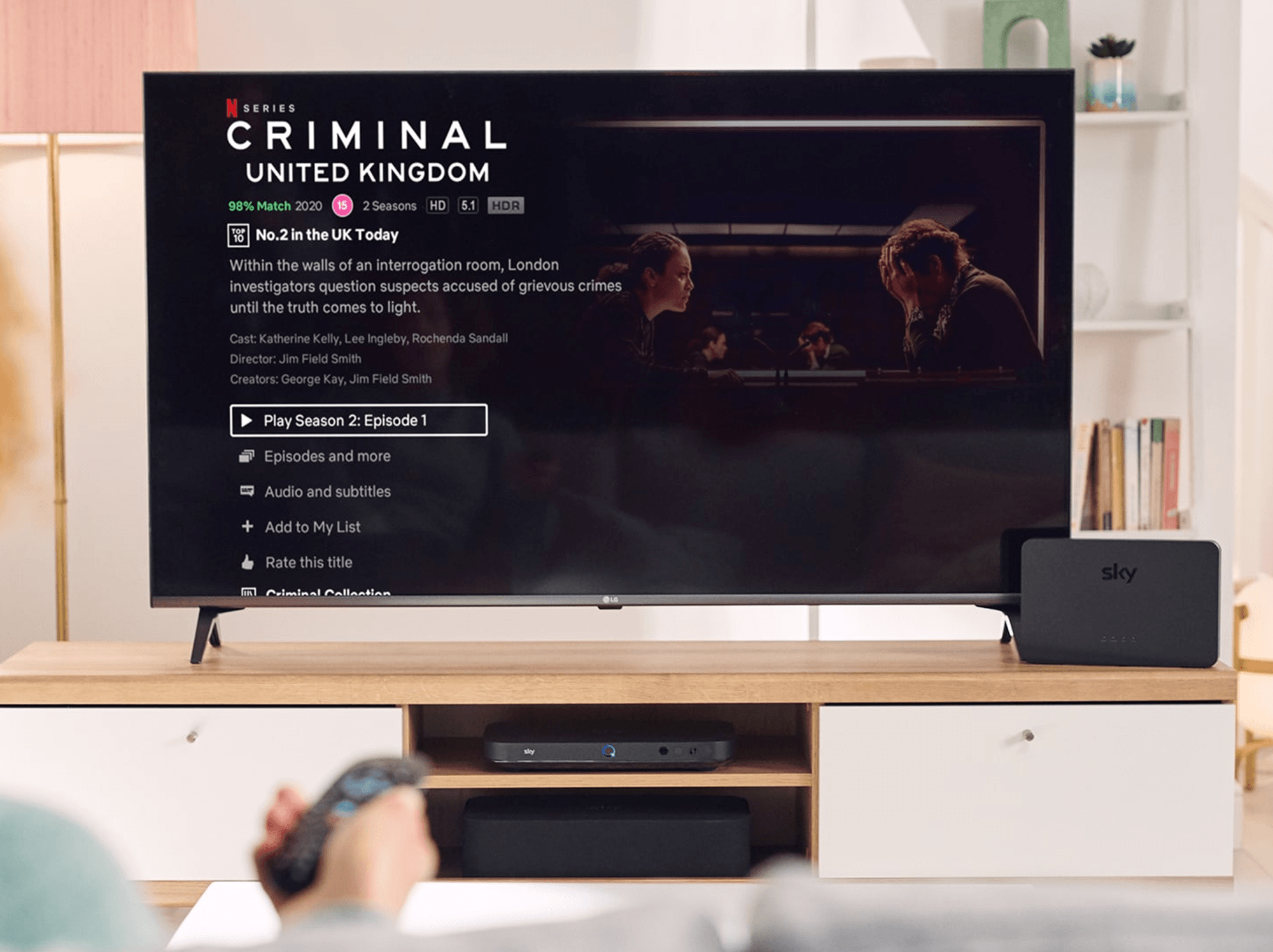 a person holds out their sky tv remote to select an episode of a netflix show on sky tv