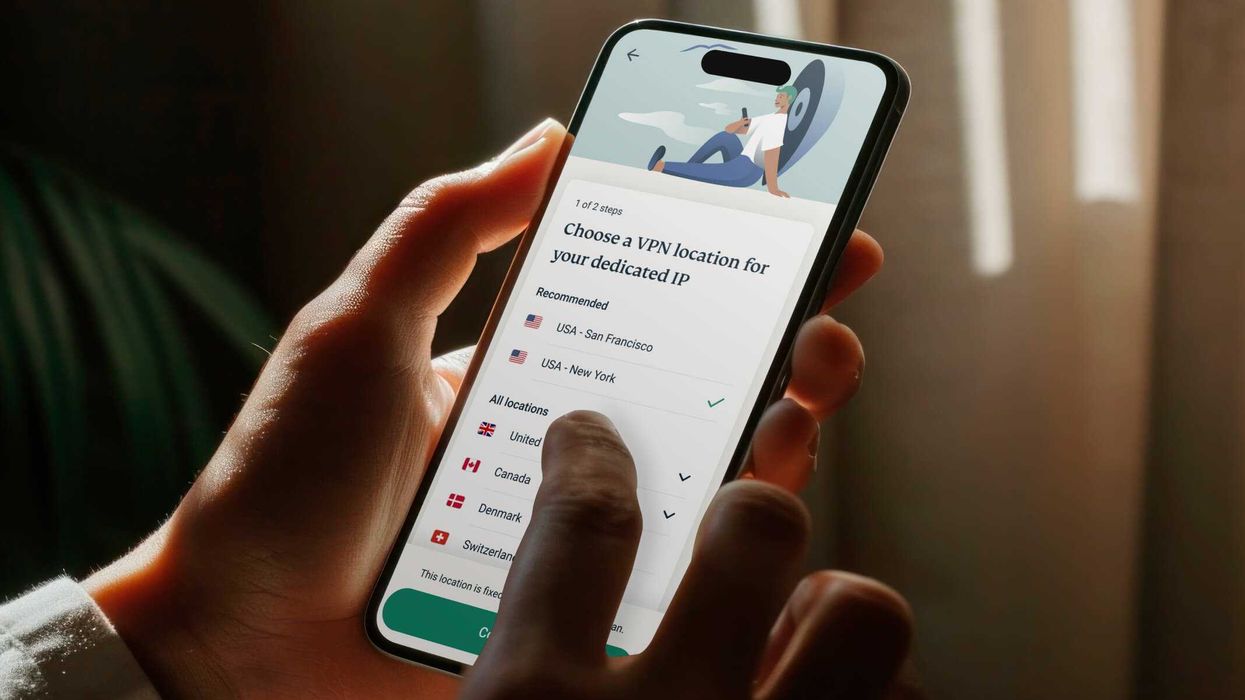 a person holds the expressvpn app on iPhone