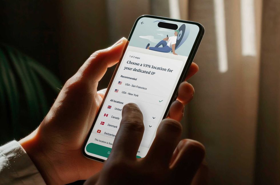 a person holds the expressvpn app on iPhone