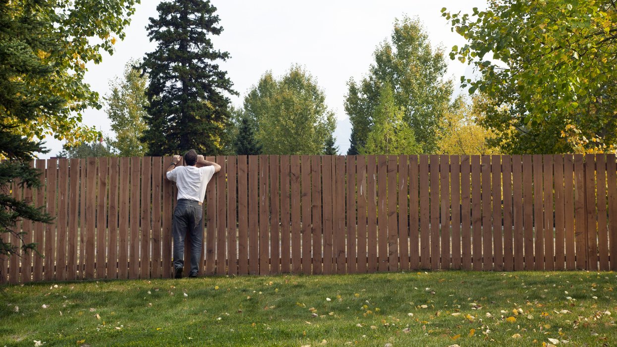 A person looking over the fence