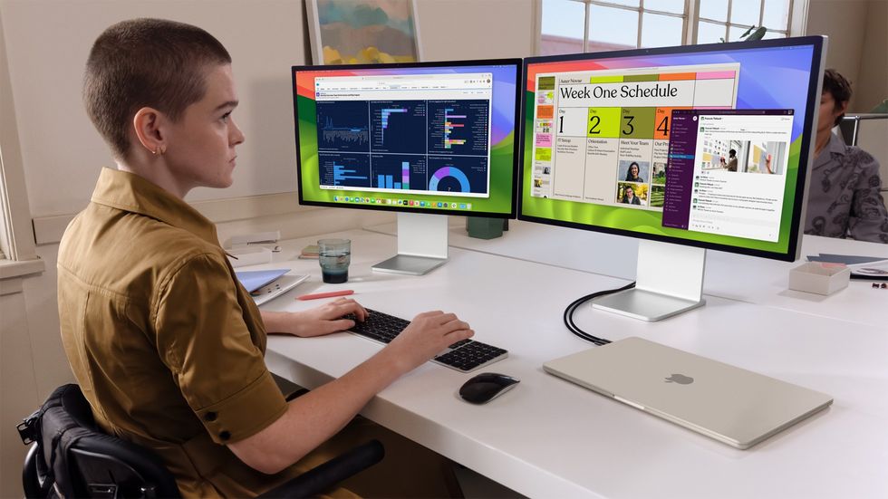 a person sits infront of two displays running macos powered by the new macbook air m3