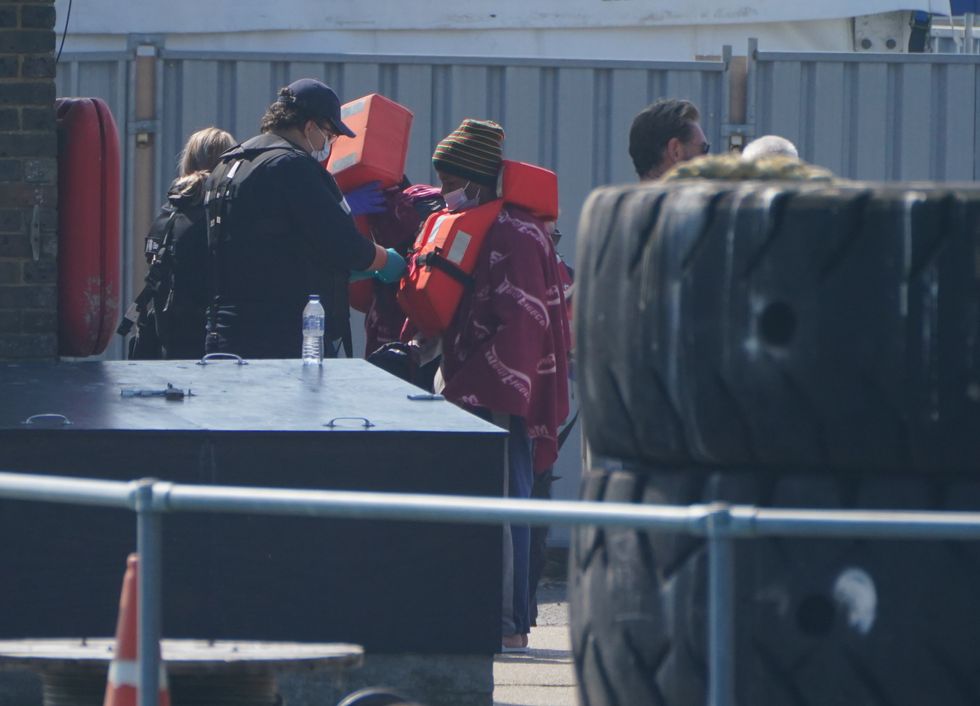 A person thought to be a migrant is brought ashore in Dover, Kent, by Border Force officers, following a small boat incident in the Channel. Picture date: Sunday September 5, 2021.