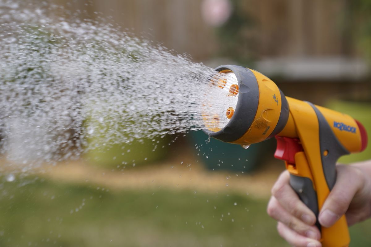 A person uses a hosepipe to water their lawn in Basingstole, Hampshire. 