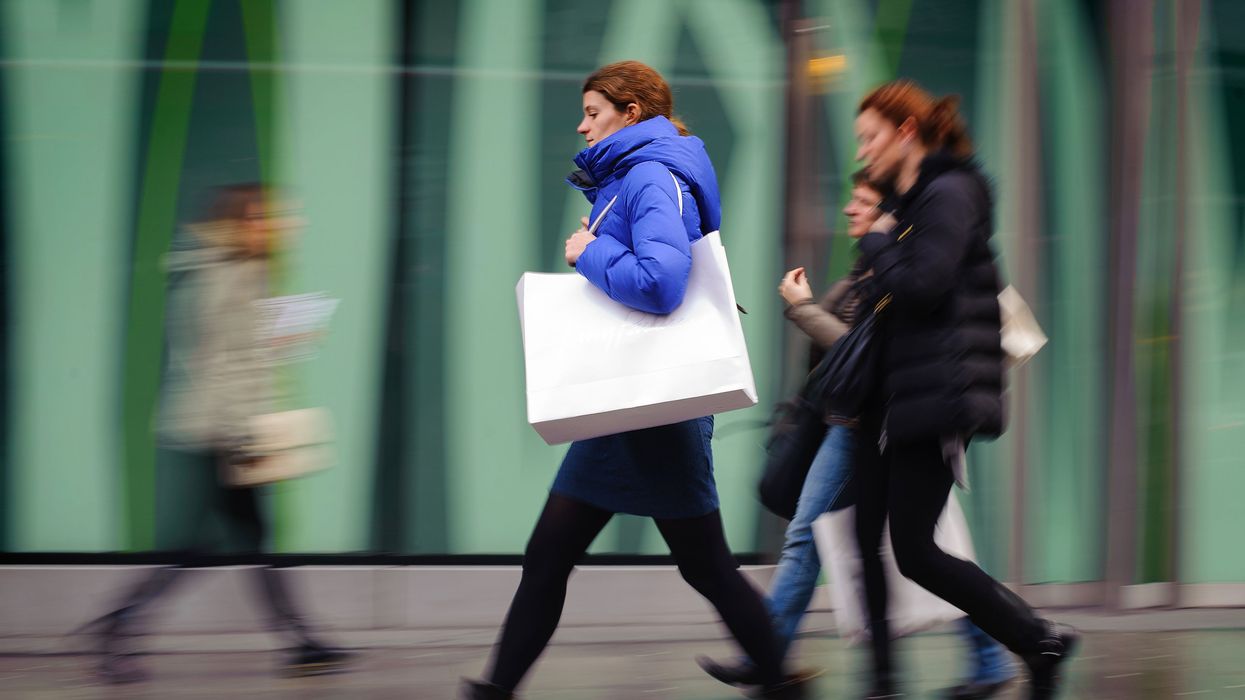 A person walking along a street with a bag