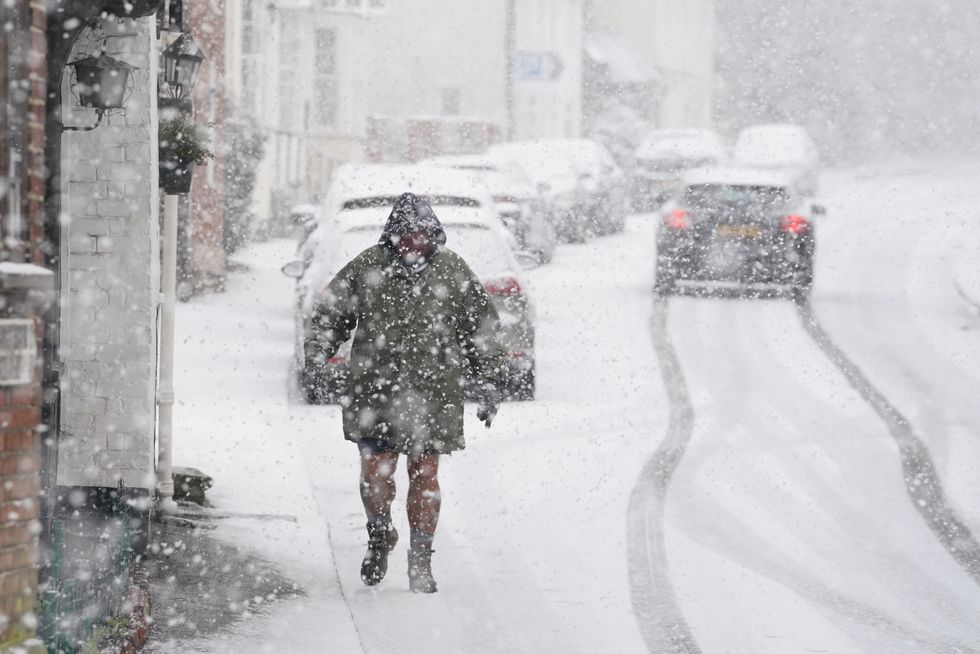 A person walking through a snow flurry in Lenham, Kent