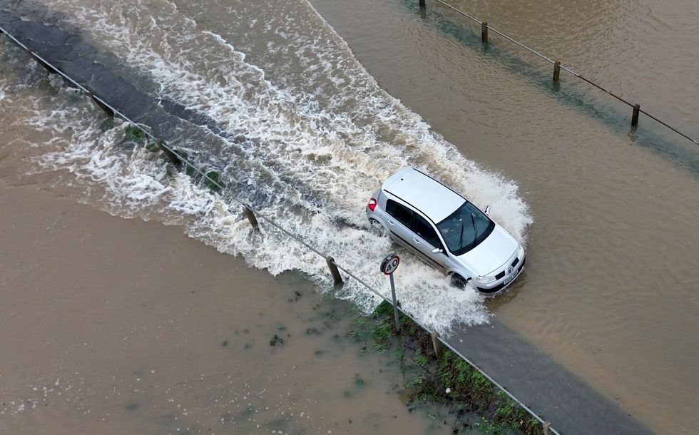 A Peugeot driving through floodwater