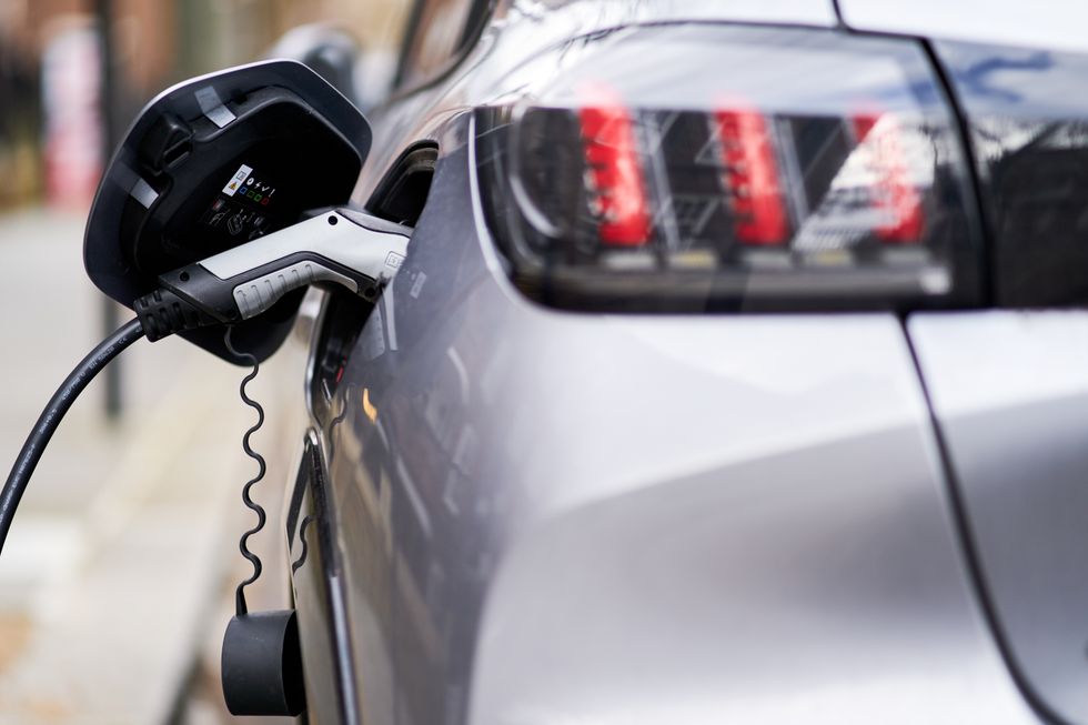 A Peugeot electric car plugged into a Source London EV charging point, London.