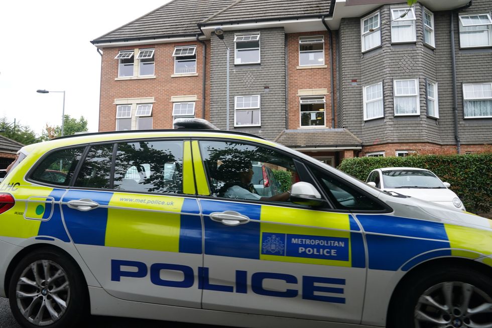A police car outside the scene at Clariat Court in Boddington Gardens, Ealing, west London, where a 58-year-old woman was stabbed to death on Monday. A 21-year-old woman, who was taken to hospital with a non-life threatening injury before being transferred to police custody, has been arrested on suspicion of murder. Picture date: Tuesday August 16, 2022.