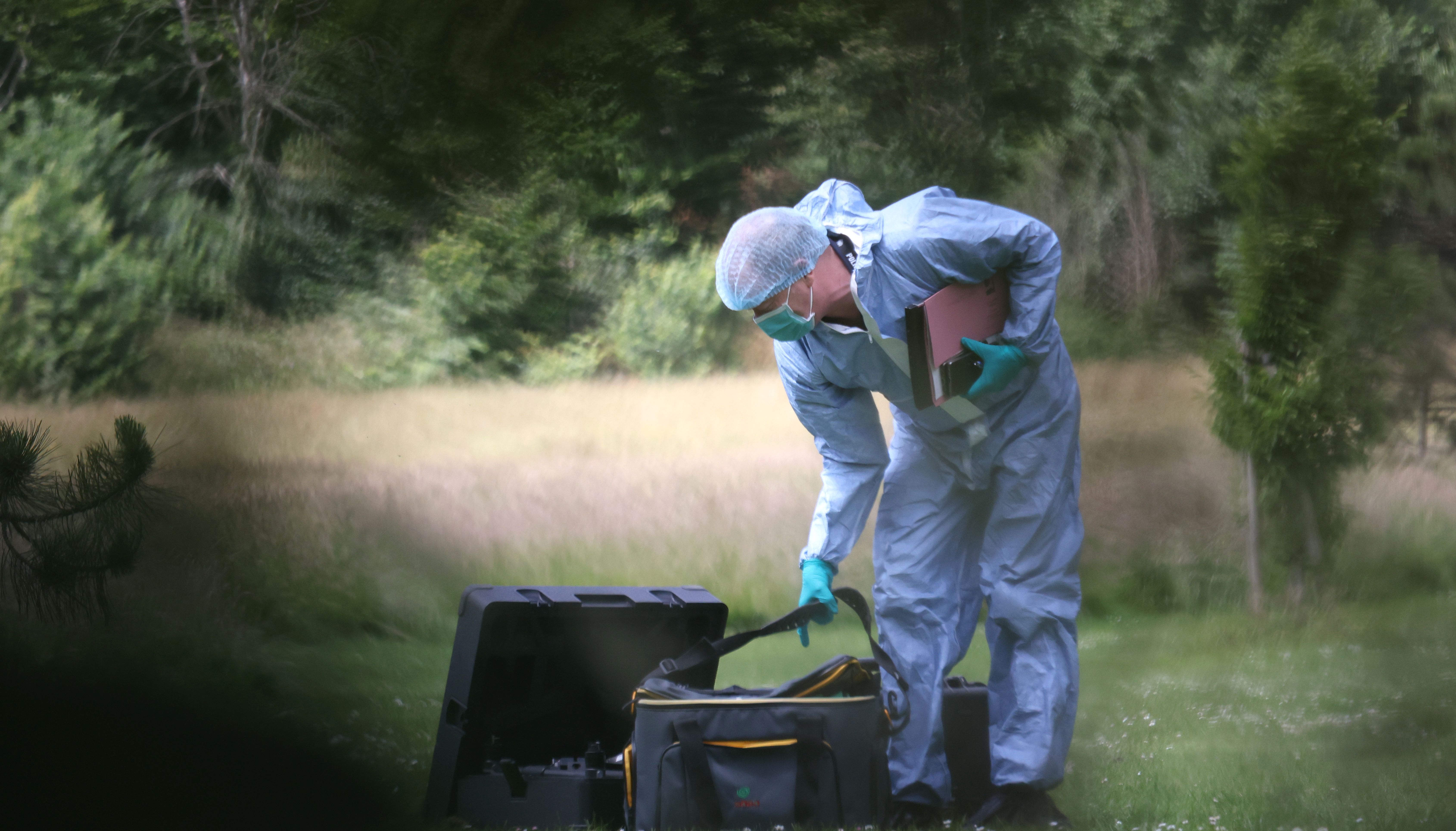 A Police forensic officer at the scene where a body was found after a fire in the early hours of this morning in Belvue Park, west London.