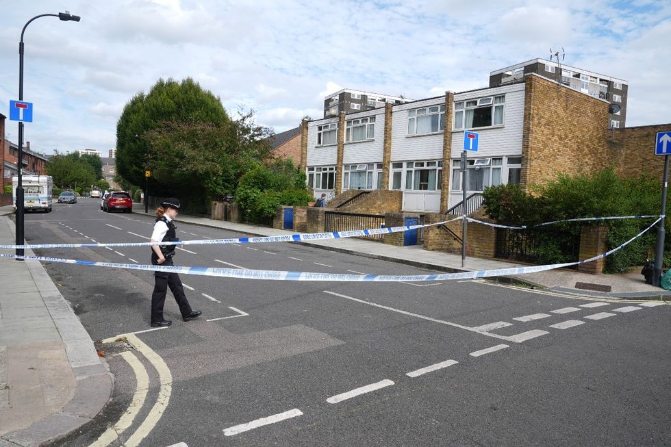 A police officer by a cordon in place near an address in Shepherd's Bush