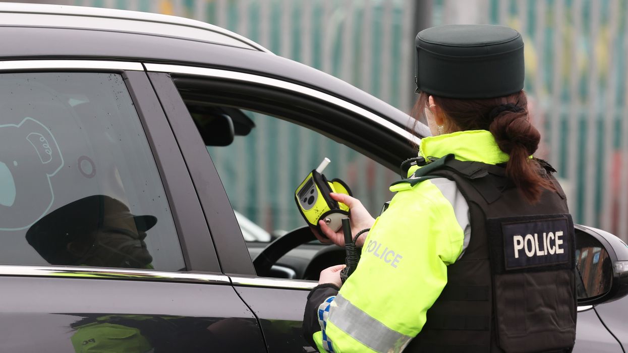A police officer conducting a roadside breathalyser test on a driver