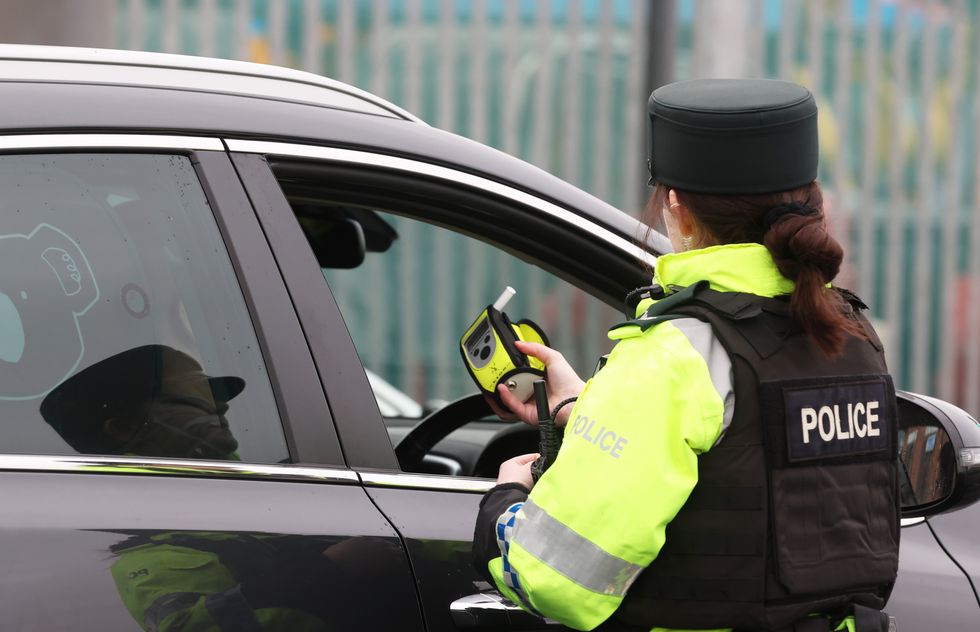 A police officer conducting a roadside breathalyser test on a driver