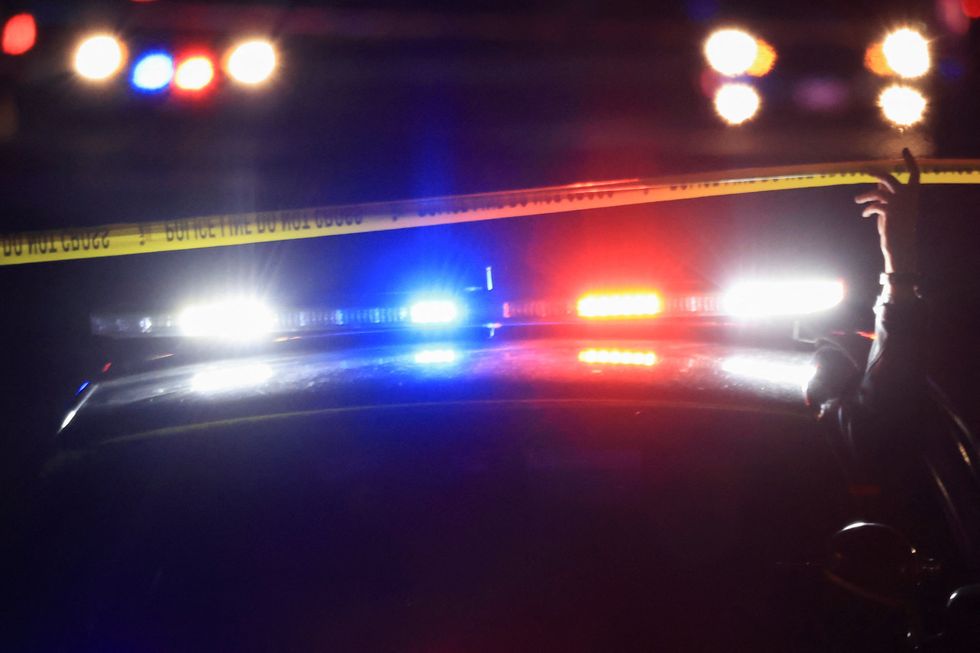 A police officer lifts barricade tape while in their vehicle as they respond to a mass shooting at the Club Q gay nightclub in Colorado Springs, Colorado, U.S., November 20, 2022. REUTERS/Kevin Mohatt