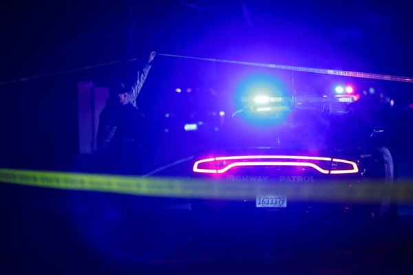 A police officer works at the scene after several people were shot at a family gathering in Stockton
