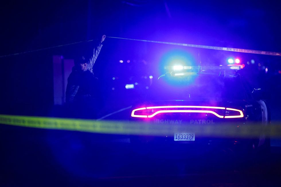 A police officer works at the scene after several people were shot at a family gathering in Stockton