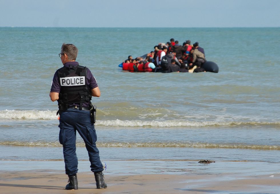 A previous photo of a French policeman watching migrants on a dinghy