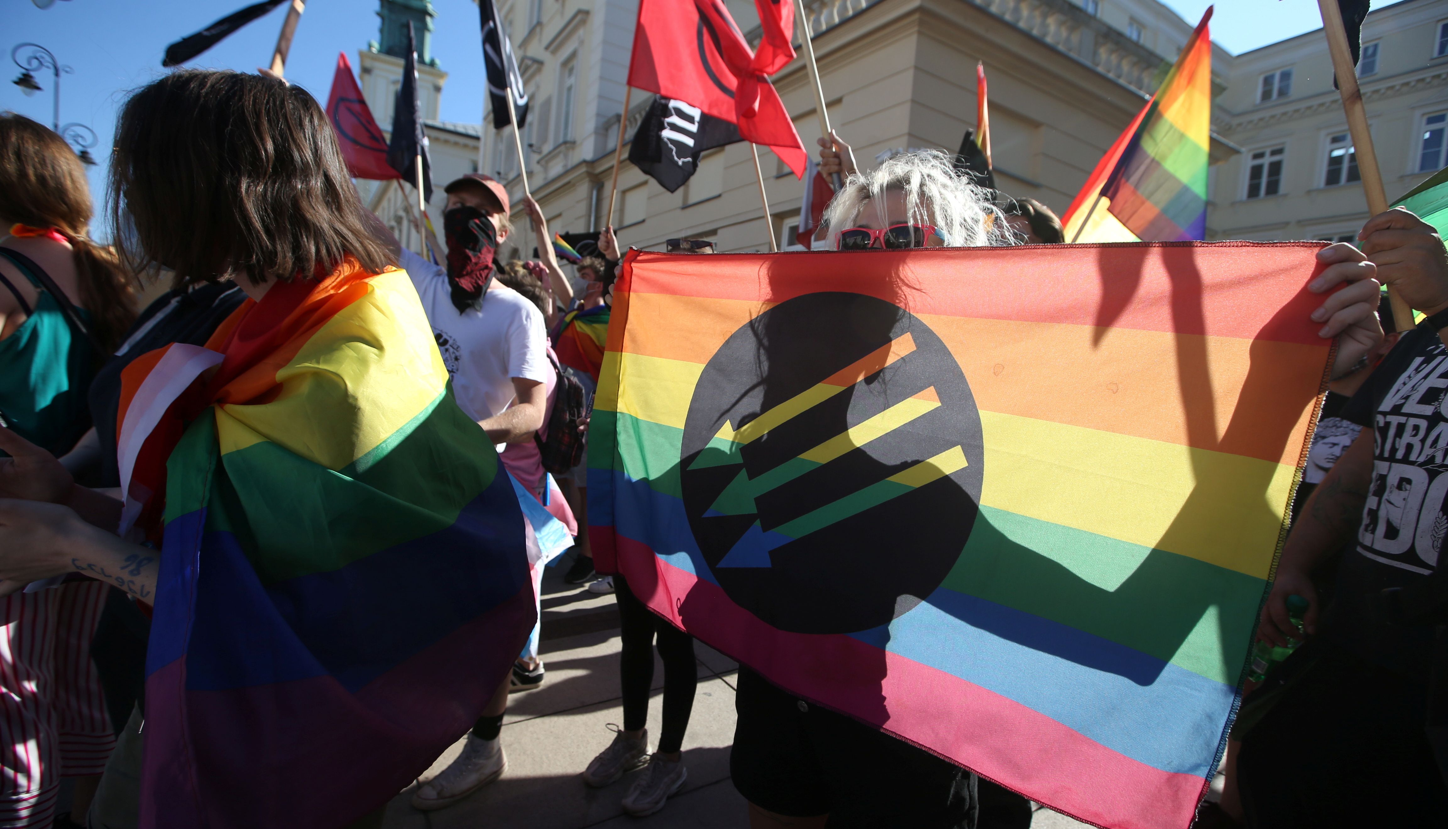 A pro-LGBT demonstrator holds a rainbow flag with an anti-fascist symbol as Polish nationalists gather to protest against what they call %22LGBT aggression%22 on Polish society, in Warsaw, Poland