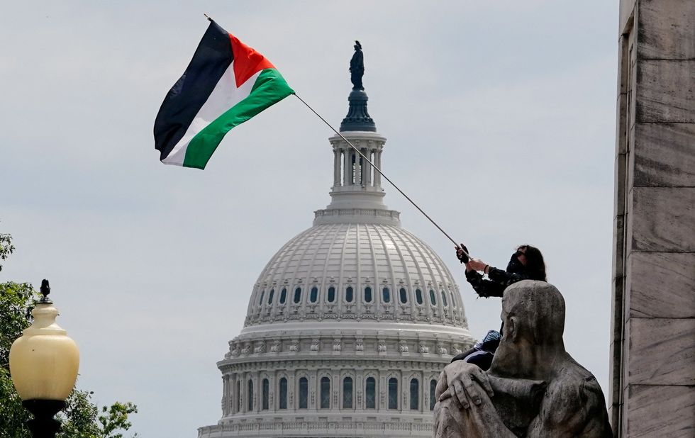 A pro-Palestinian demonstrator waves a Palestinian flag with the Capitol dome seen in the background