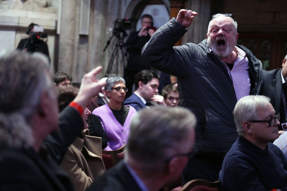 A pro-Palestinian protester is removed from the room after interrupting shadow foreign secretary David Lammy during his speech